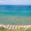 Spiaggia con ombrelloni e mare calmo. Vista aerea di una costa sabbiosa.