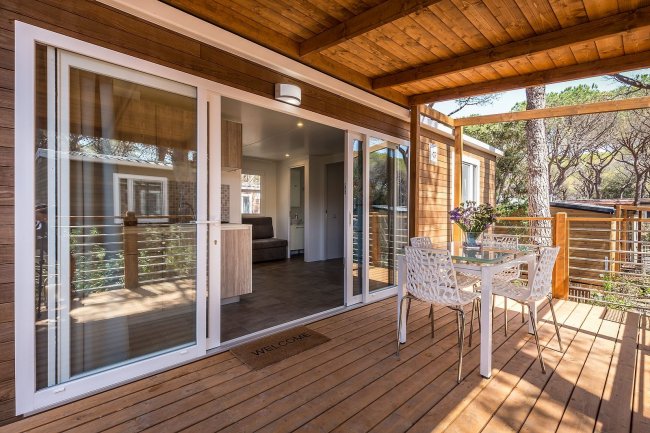 Veranda di chalet con tavolo e sedie, vista interna.