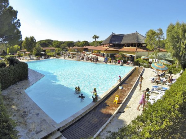 Una grande piscina con persone e sedie a sdraio.