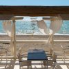 Tavoli e sedie sotto una pergola sulla spiaggia.