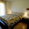 Camera da letto con letto matrimoniale, copripiumino a fantasia floreale e due lampade sui comodini.
