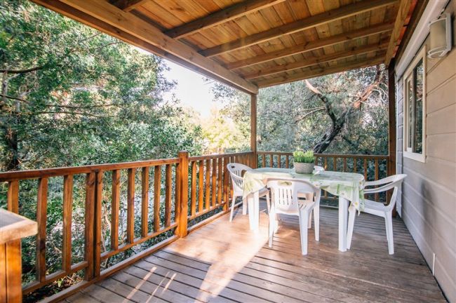 Terrazza coperta con tavolo e sedie di plastica.