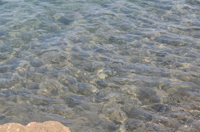 Acqua limpida sopra un fondale roccioso.