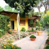 Casa gialla con giardino fiorito e sentiero in mattoni.